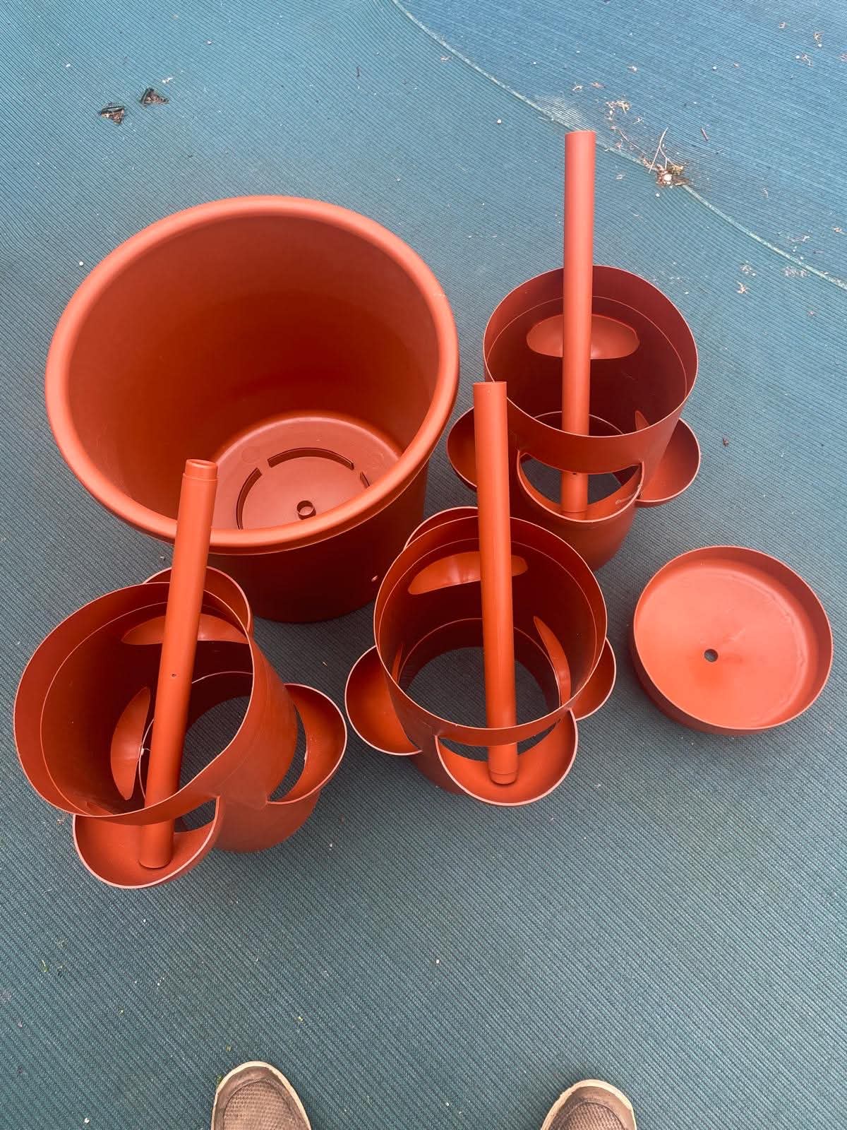All planter tower components unboxed: base pot, 4 modular tiers, internal tube, and top rim